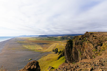 photo of brown cliff near field during daytime thumbnail