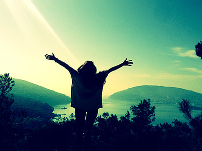 silhouette of person raising hands near trees thumbnail