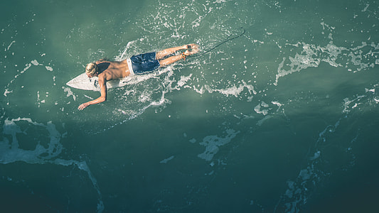 man in blue and white shorts surfboarding thumbnail