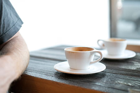coffee filled white ceramic mug on top of brown wooden table thumbnail