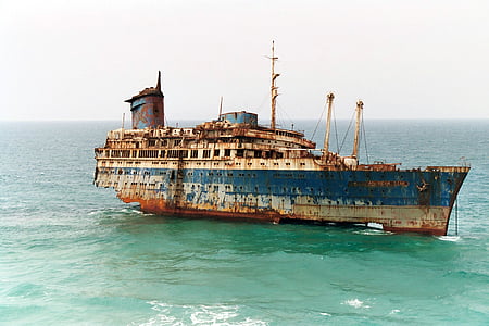 photo of blue and brown ship surrounded by body of water thumbnail