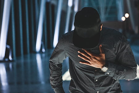 man wearing black dress shirt holding chest thumbnail