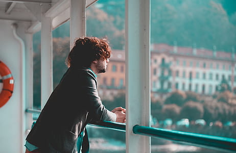man standing beside metal rails during daytime thumbnail