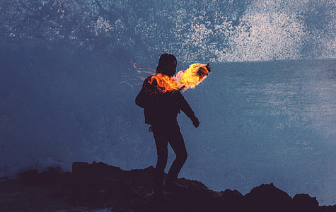 person standing on the mountain holding torch with fire thumbnail