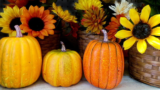 three pumpkins front of yellow sunflowers table decoration thumbnail