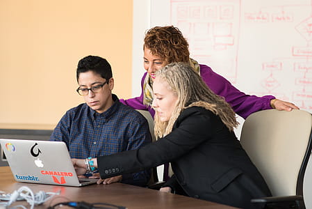 Closeup Photo of Three Person Looking at Macbook Air thumbnail