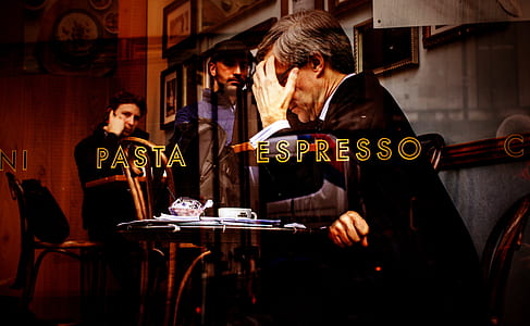 man holding forehead sitting on chair beside table thumbnail