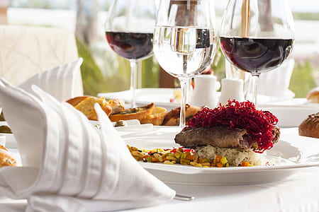 white with cooked food beside wine glasses thumbnail