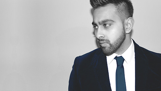 man wearing necktie and suit jacket beside wall thumbnail