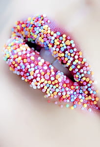 woman's lip with assorted-color candies thumbnail