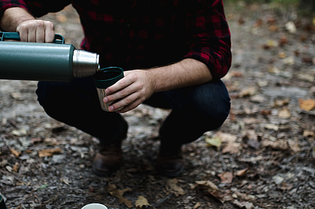 person pouring water from carafe to mug thumbnail