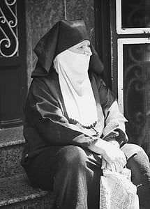 grayscale photo of woman sitting on stair thumbnail