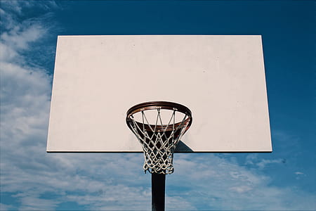 white and black basketball hoop under blue sky thumbnail