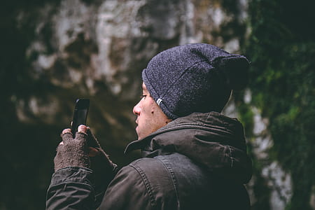 Man Wearing Beanie Holding Smartphone thumbnail