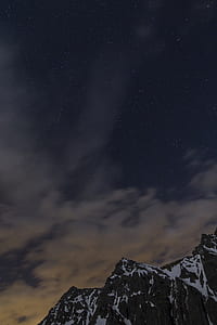 snow capped gray mountains under the gray couds thumbnail