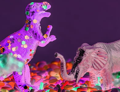 focus photography of elephant and T-rex toys thumbnail