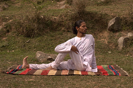 man sitting on mat near rocks on hillside during daytime thumbnail