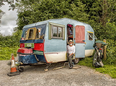Photo Of A Man In White Long-sleeved Top on Blue And White Pop-up Camper thumbnail