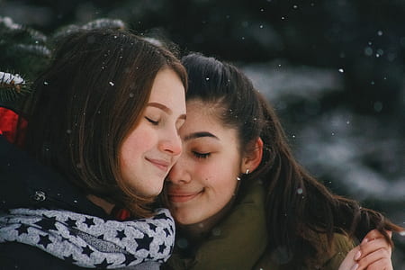 two women hugging each other while snowfall thumbnail
