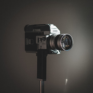 grey and black Canon camera with stand thumbnail