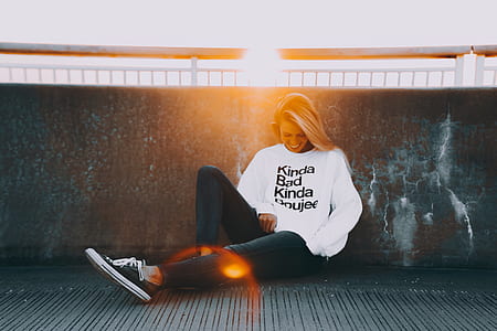woman sits on floor against concrete wall thumbnail