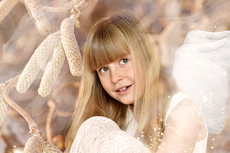 child in white sleeveless top sitting with brown background thumbnail