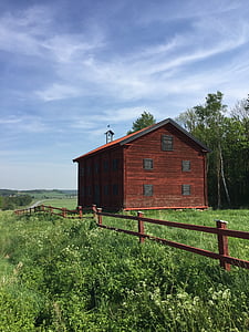 reddish-brown barn on grass field under white clouds\ thumbnail