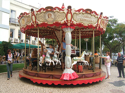 children riding on gray and red carousel thumbnail