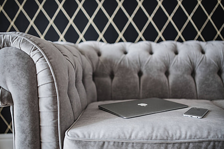 Elegant grey sofa with a laptop, an iPhone and a magazine thumbnail