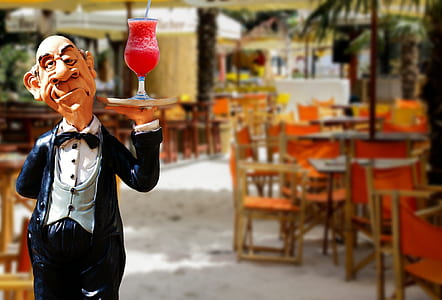 selective focus photo of man carrying glass of drink figurine thumbnail