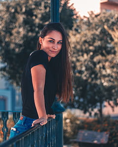 Woman in Black T-shirt Standing Near Green Trees thumbnail