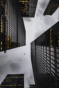 worms eye view photography of skyscrapers and airplane thumbnail