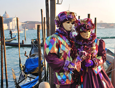 couple wearing purple and teal costumes with masquerade masks thumbnail