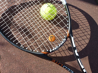 tennis ball under black Head tennis racket thumbnail