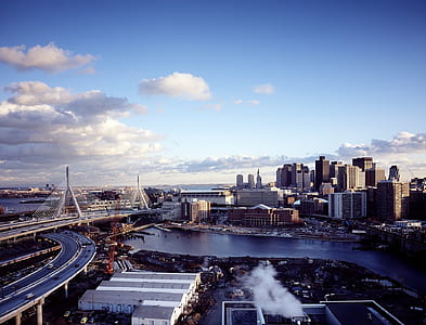 grey and black high-rise buildings under white cloudy and blue sky at daytime thumbnail