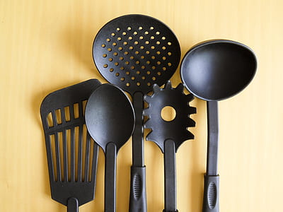 black cooking utensils on beige wooden surface thumbnail