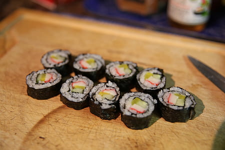 sushi rolls on brown wooden chopping board thumbnail