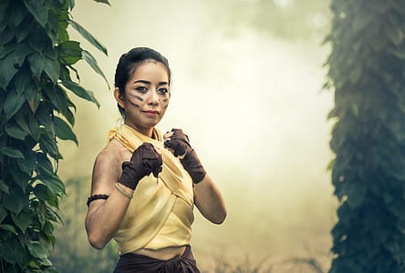 woman in yellow halter top beside green leaves thumbnail