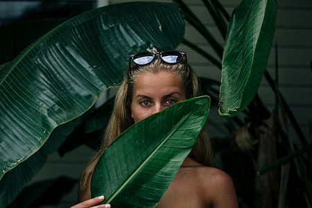 woman holding green leaf cover his face thumbnail
