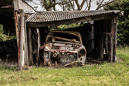 wrecked car inside brown shed thumbnail