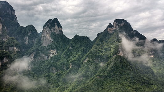 mountains with green trees during daytime thumbnail
