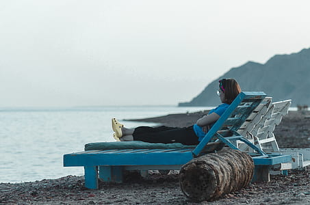 woman sitting on lounger chair at seashore thumbnail