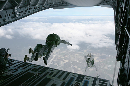 three people in grey army suit sky diving thumbnail