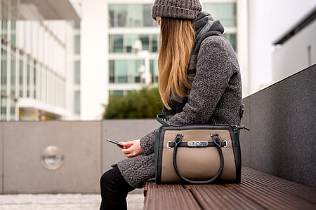 woman sitting on bench outside and using smartphone thumbnail