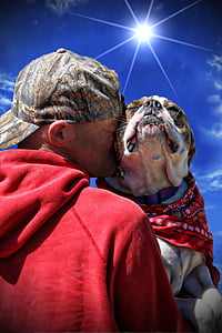low light photography of man kissing dog thumbnail