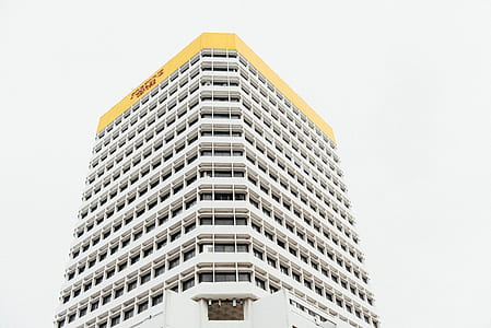 low-angle photography of white and yellow concrete high-rise building at daytime thumbnail