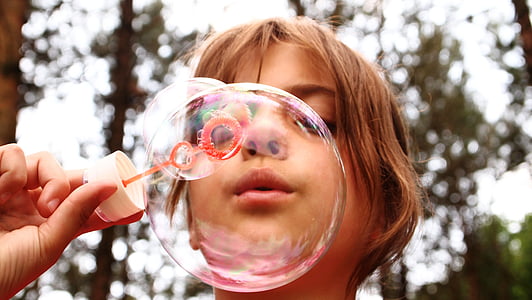 selective focus photography of girl blowing bubbles thumbnail
