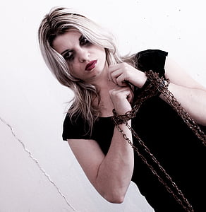 woman in black dress standing against wall thumbnail