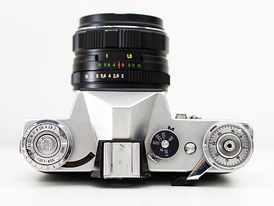 gray and black DSLR camera placed on white surface thumbnail