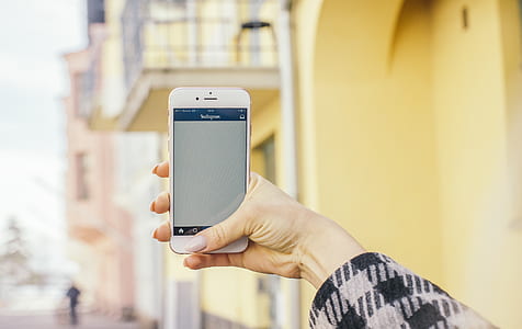 person holding rose gold iPhone 6s displaying white screen thumbnail